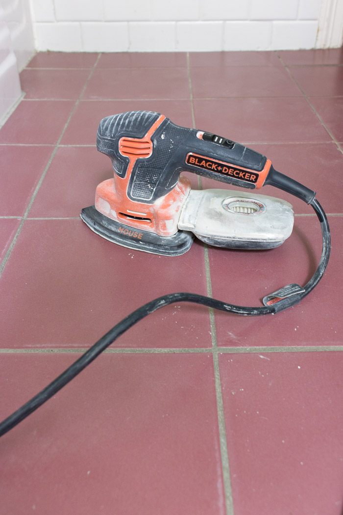 A handheld sander used to prepare tile floors for painting