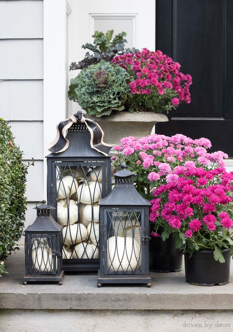 Love this trio of black lanterns filled with pumpkins (and the mums too!) for a fall front porch