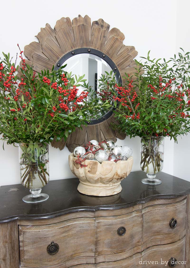 Branches clipped from backyard bushes plus berry bundles and a bowl full of ornaments make beautiful, simply entry way decor for Christmas.