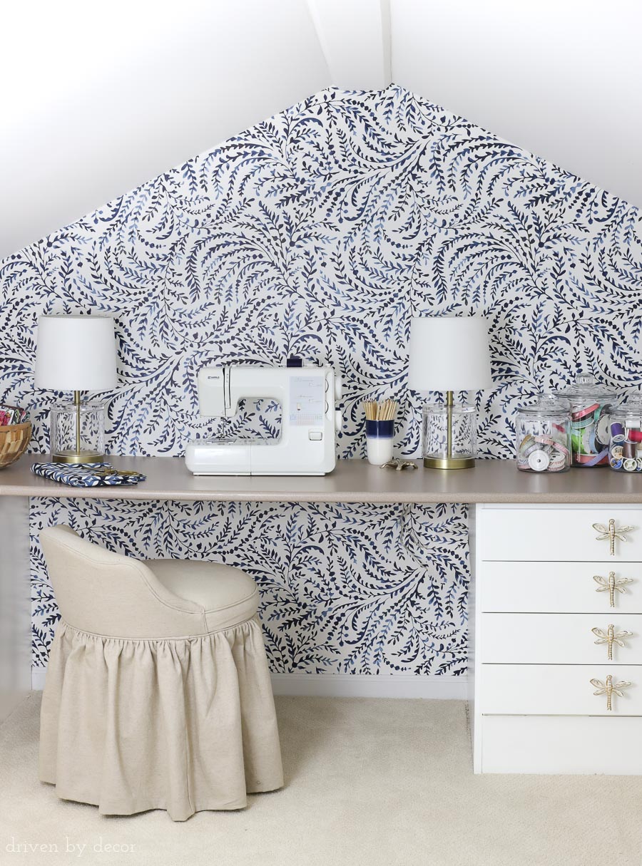 Such a cute kids craft room! Love the blue and white feather wallpaper and the brass and acrylic lamps!