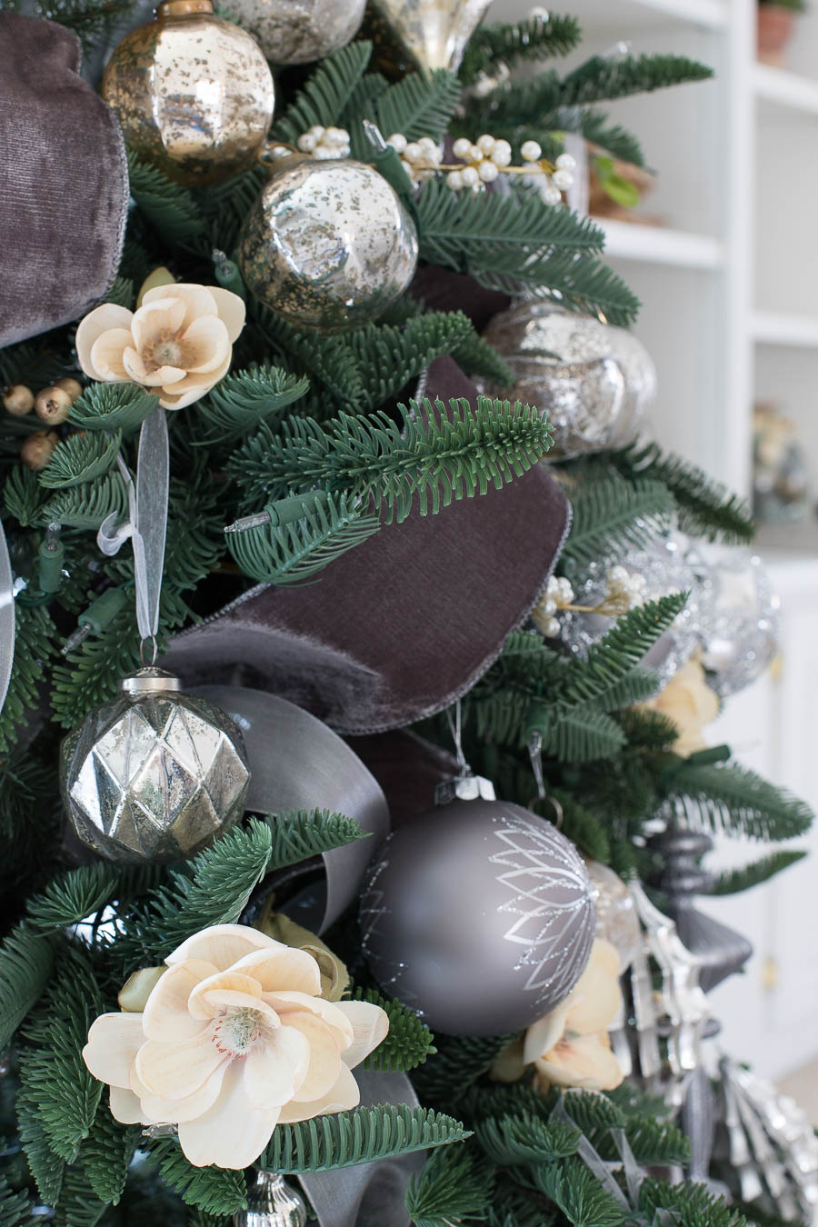 Love how she used faux floral stems along with the velvet ribbon and silver ornaments to decorate her Christmas tree