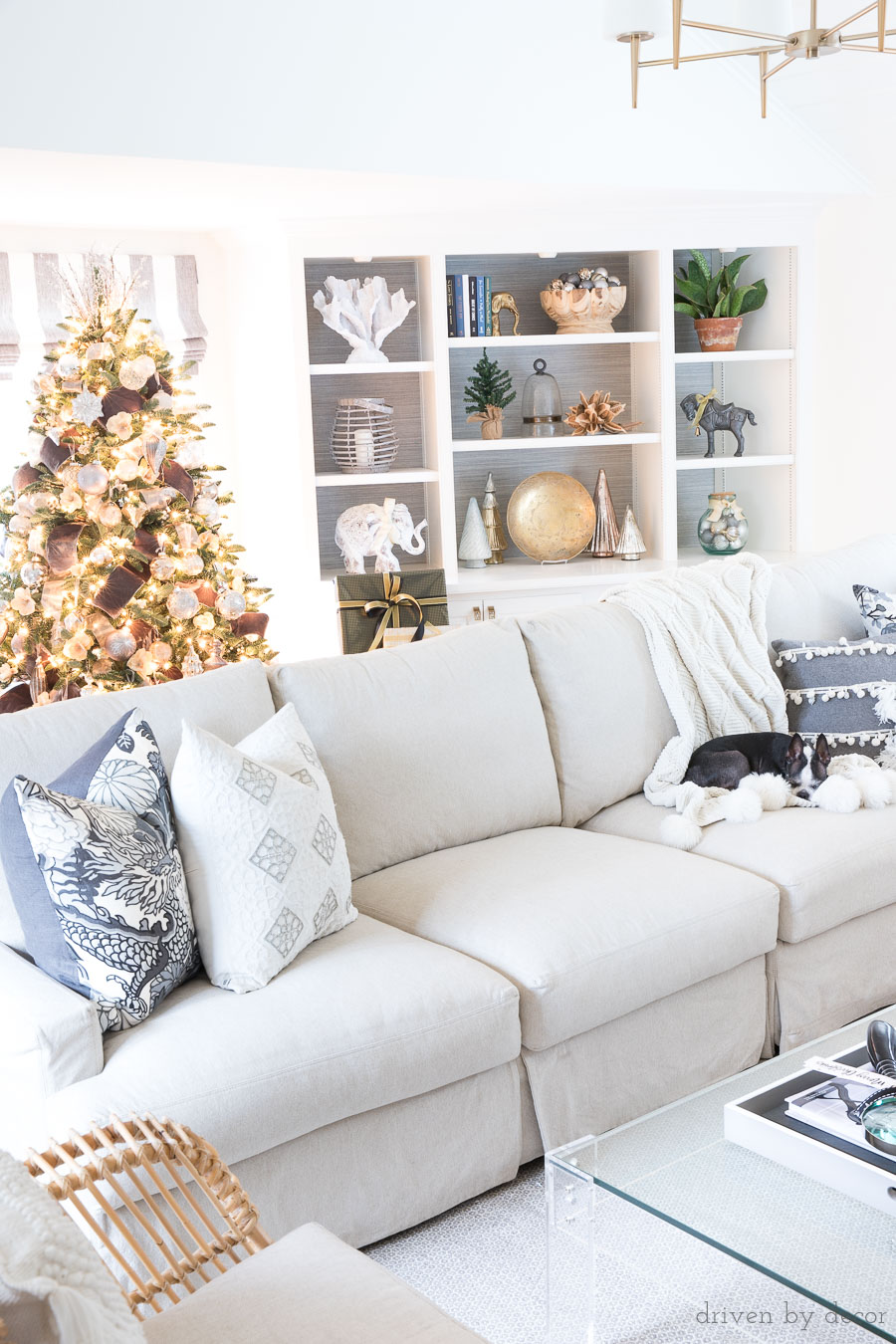 Family room at Christmas with slipcovered sectional, built in bookcases, acrylic coffee table, and a beautiful Christmas tree!