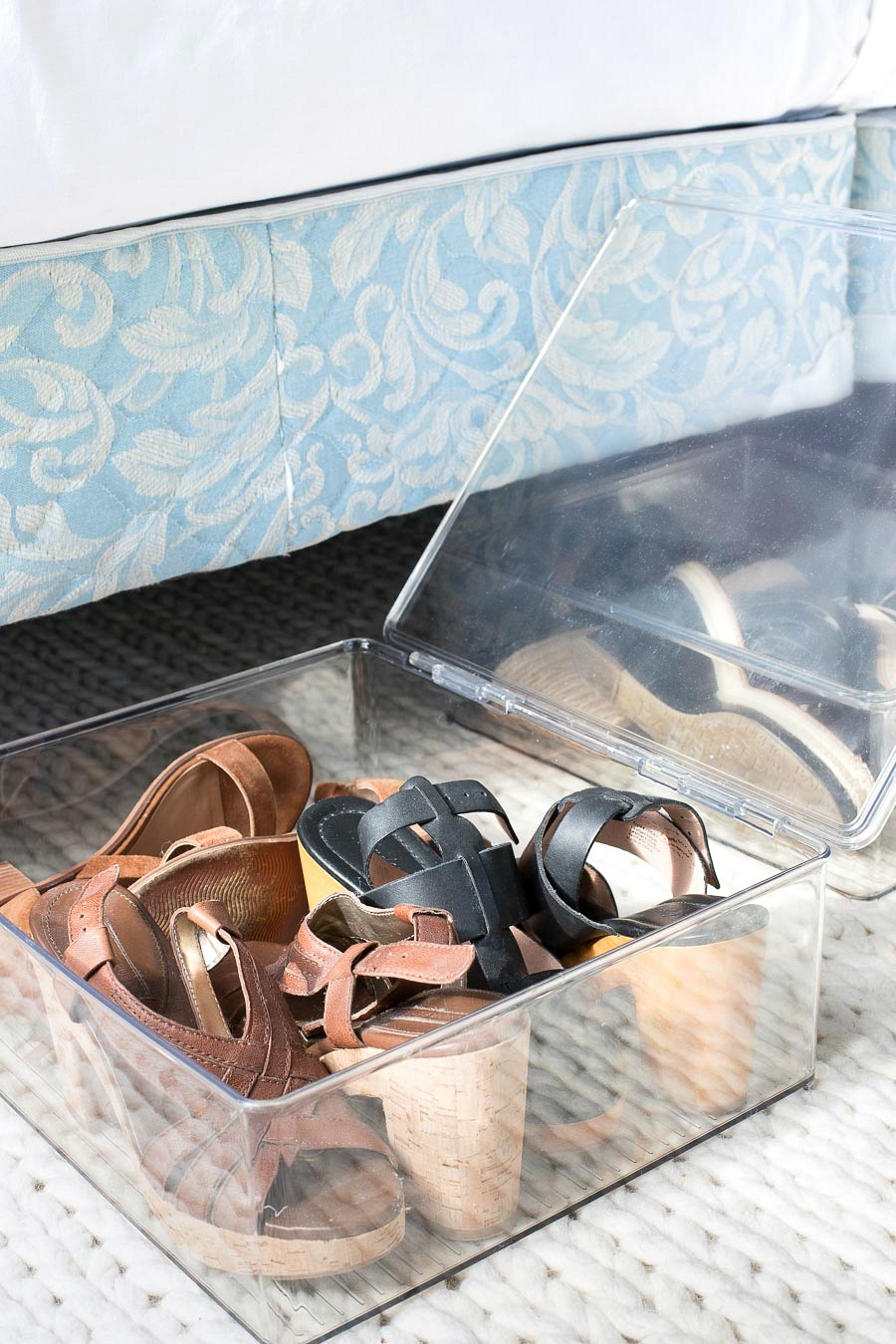 Shoes stored in hinged acrylic boxes that are easily stored under the bed!