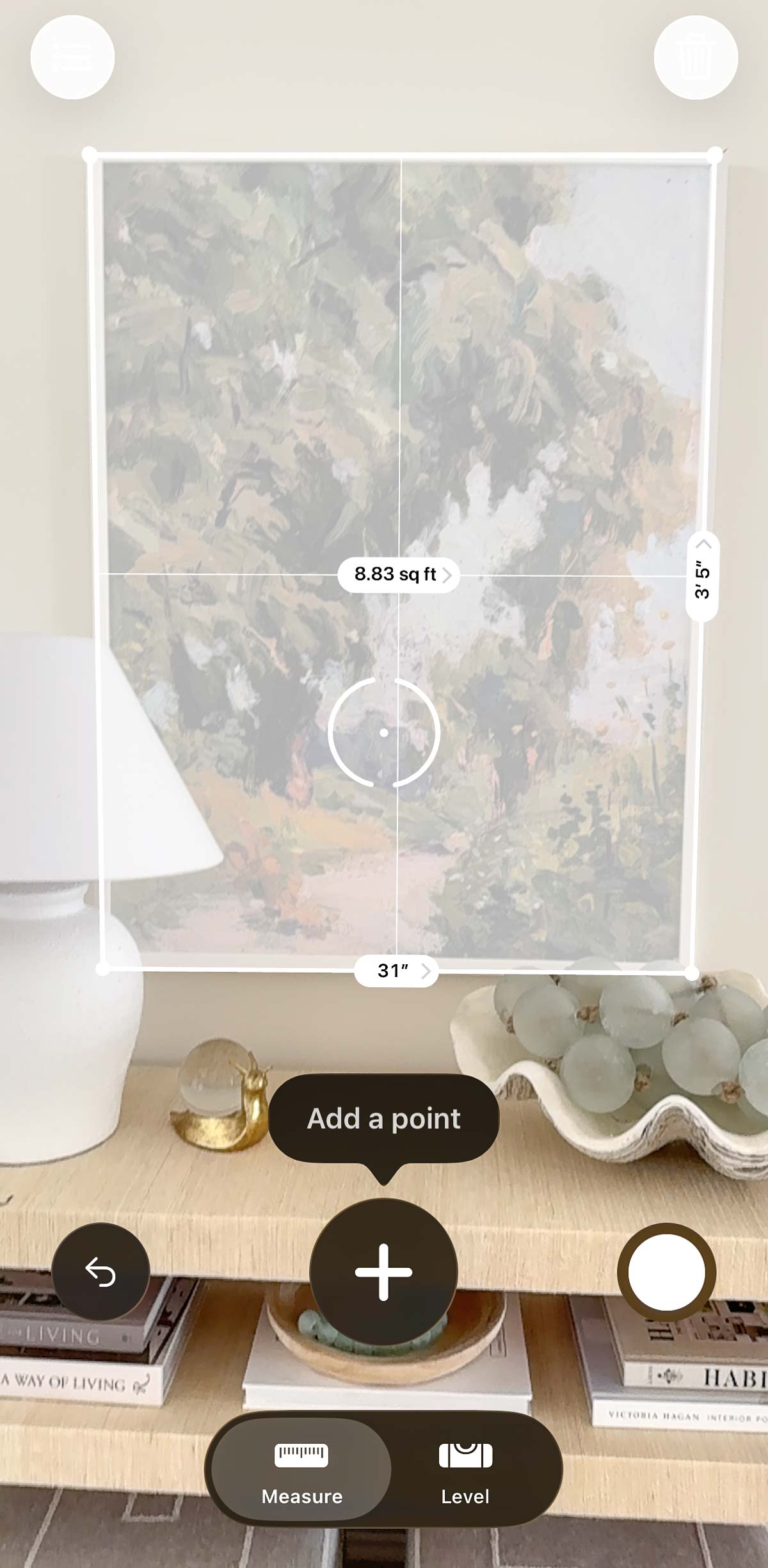 Showing the use of the Measures app to measure a rectangular piece of art