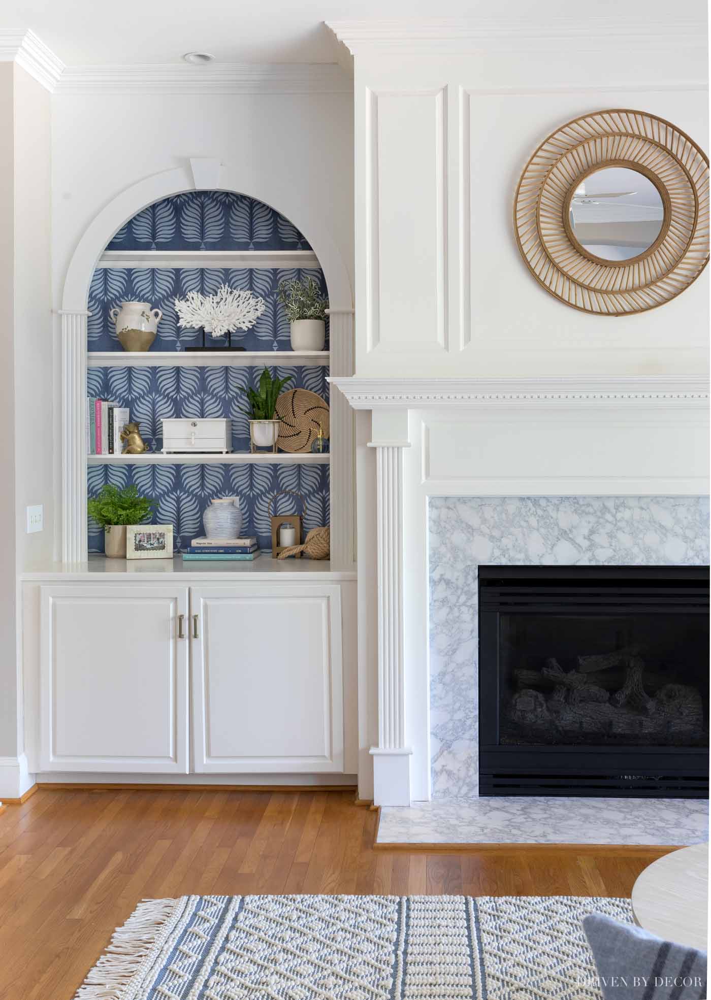 Love the look of a simple rattan mirror above the fireplace!