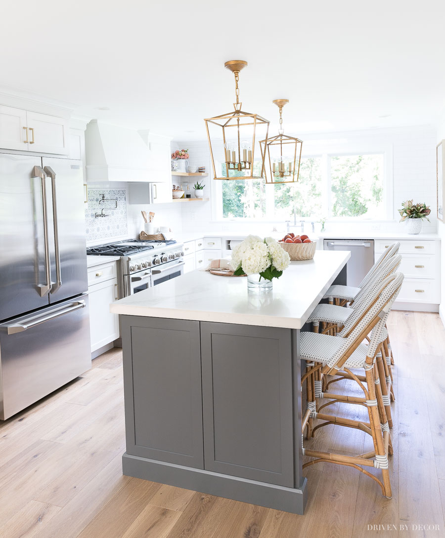 Love this newly remodeled kitchen with gray and white cabinets and brass accents! Such a huge difference from what it looked like before!