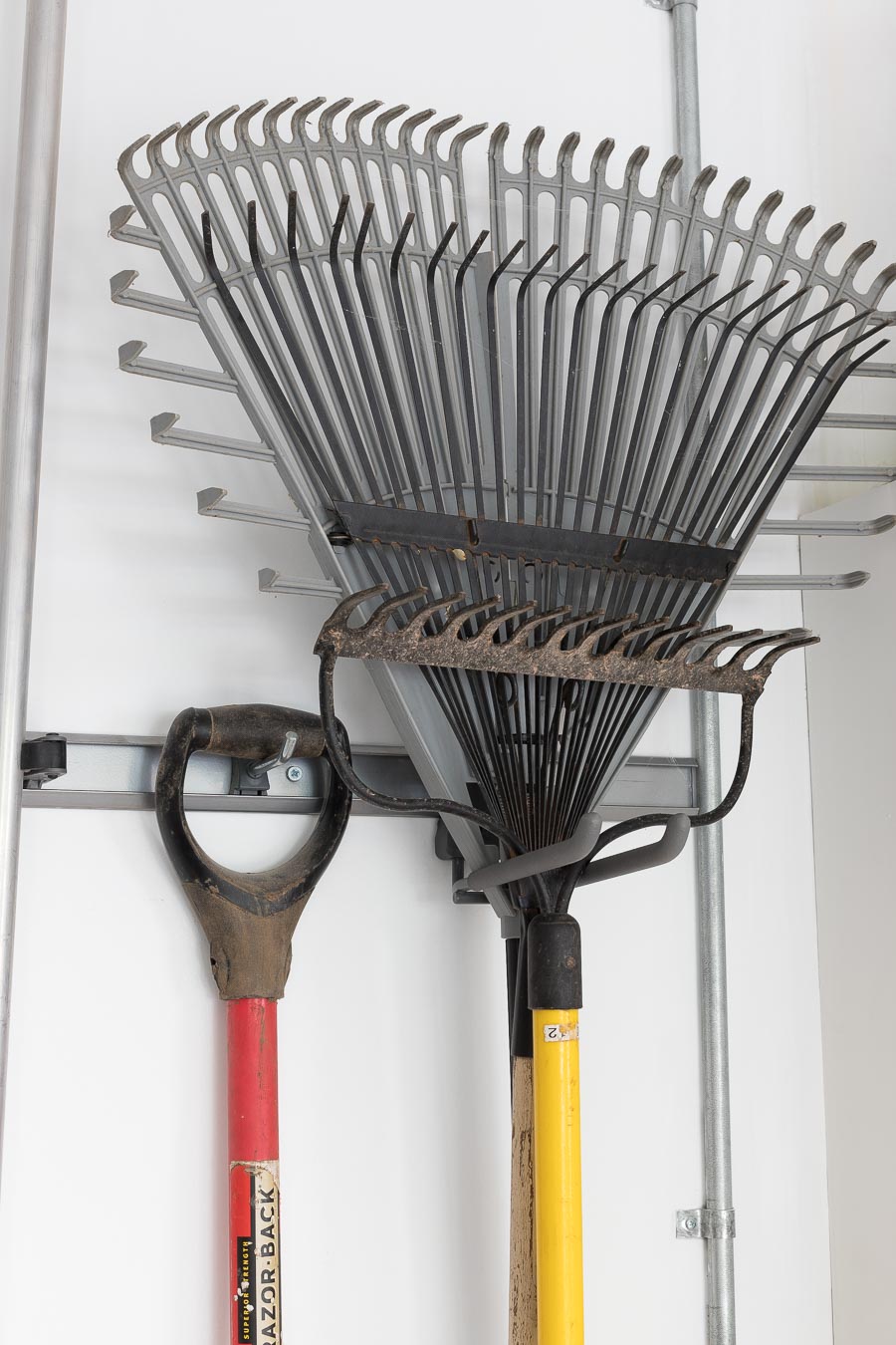 Elfa hooks for hanging long handled tools in the garage - love this organization system!