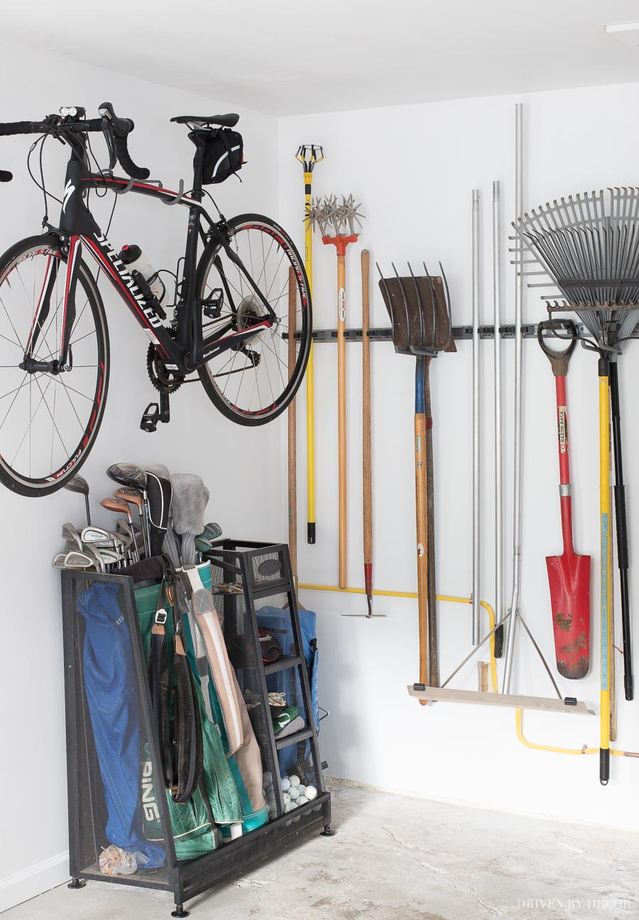 Smart ideas for storing your long handled tools, golf bags, and bike as part of a garage organization project!