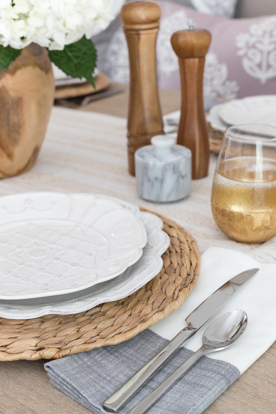 Beautiful, simple table setting with woven chargers and black stripe napkins