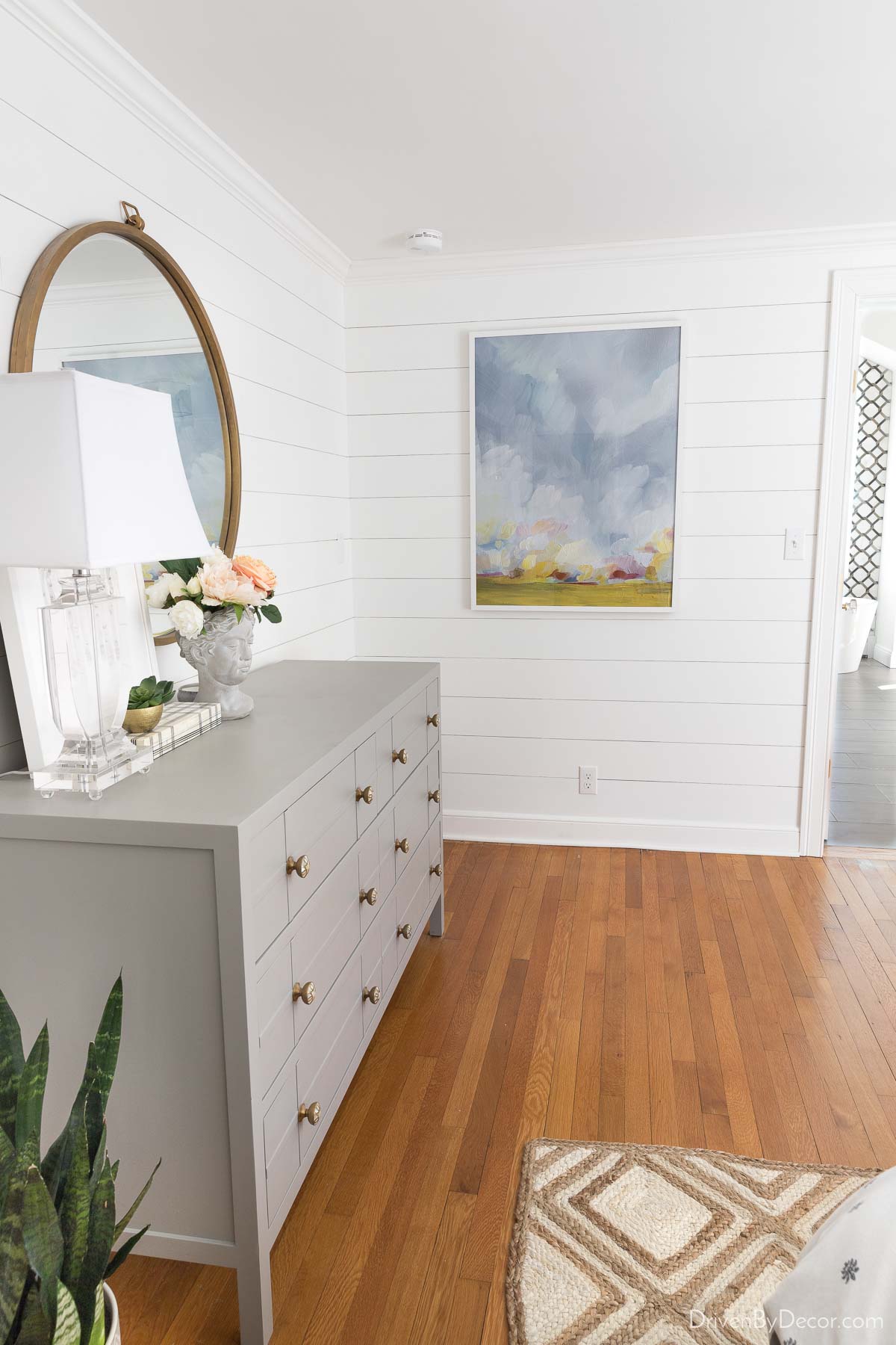 Bedroom with large picture hung on shiplap wall - shows how high to hang a single picture