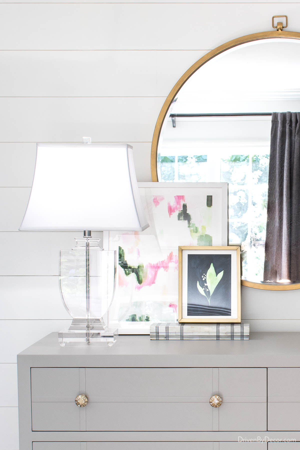 Acrylic urn-shaped table lamp on gray dresser