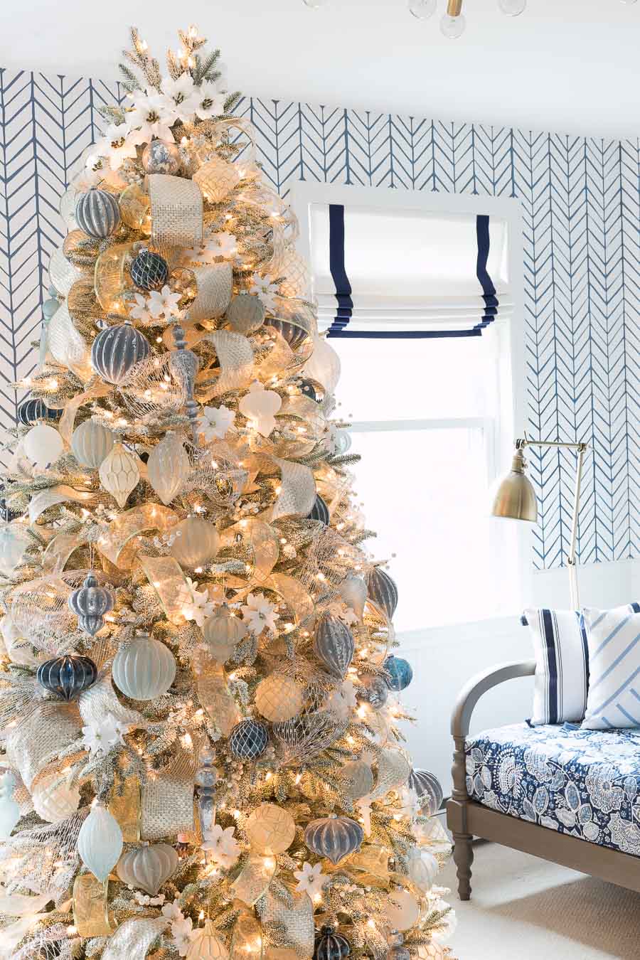 Gorgeous Christmas tree decorated in blue, white, silver, and gold with white poinsettia accents