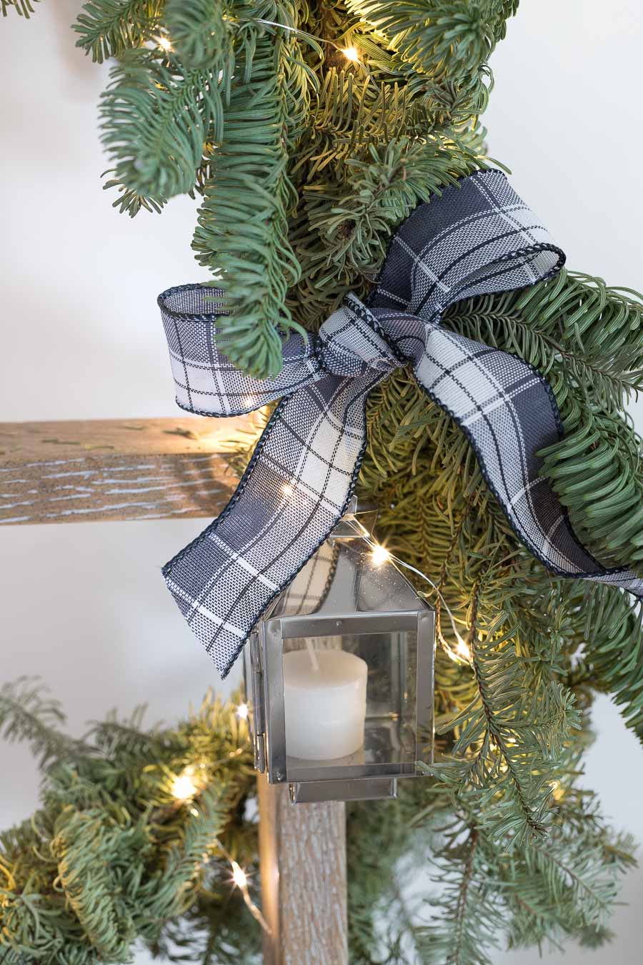 Mini lanterns tied on to Christmas garland as part of this super cute Christmas card display!