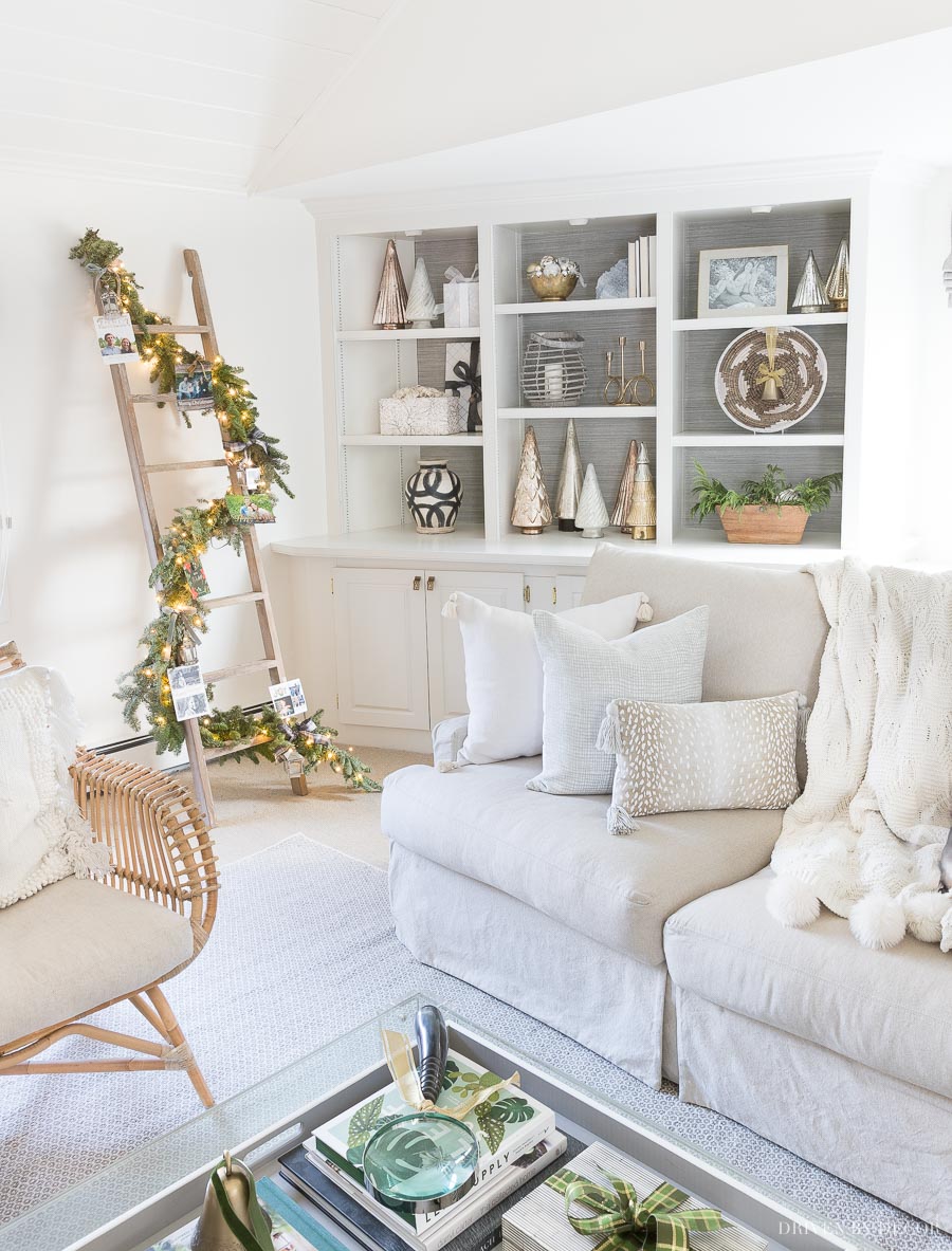 Loving this idea for displaying Christmas cards in our living room - cards are tied on a garland wrapped around a whitewash ladder!