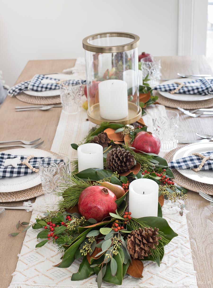 Gorgeous! This post gives you the step by step to making a live greenery table runner with magnolia leaves, greenery, fruit, and pinecones!