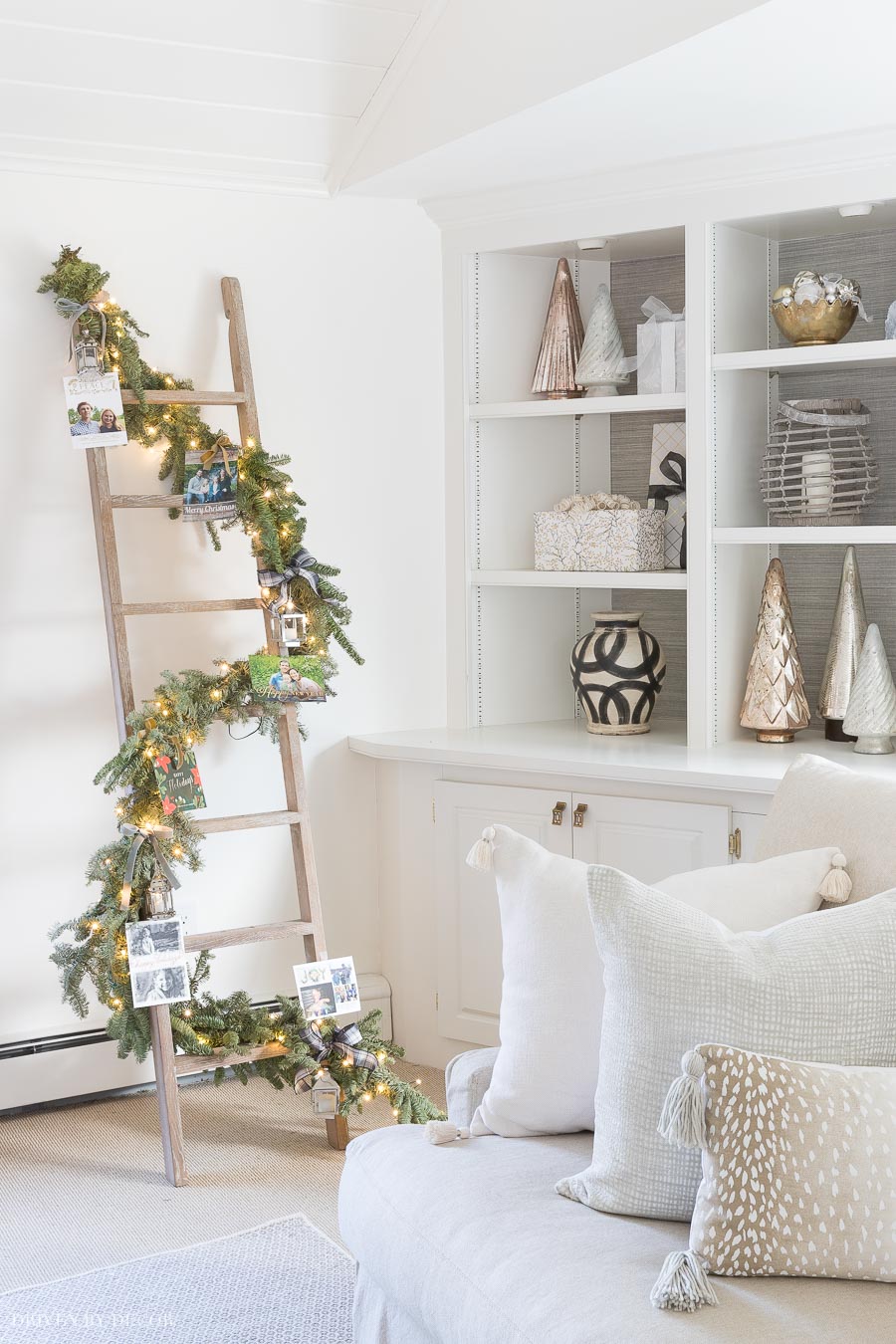 Wrap a garland and twinkle lights around a ladder and tie on Christmas cards for a beautiful, unique way to display your holiday cards!