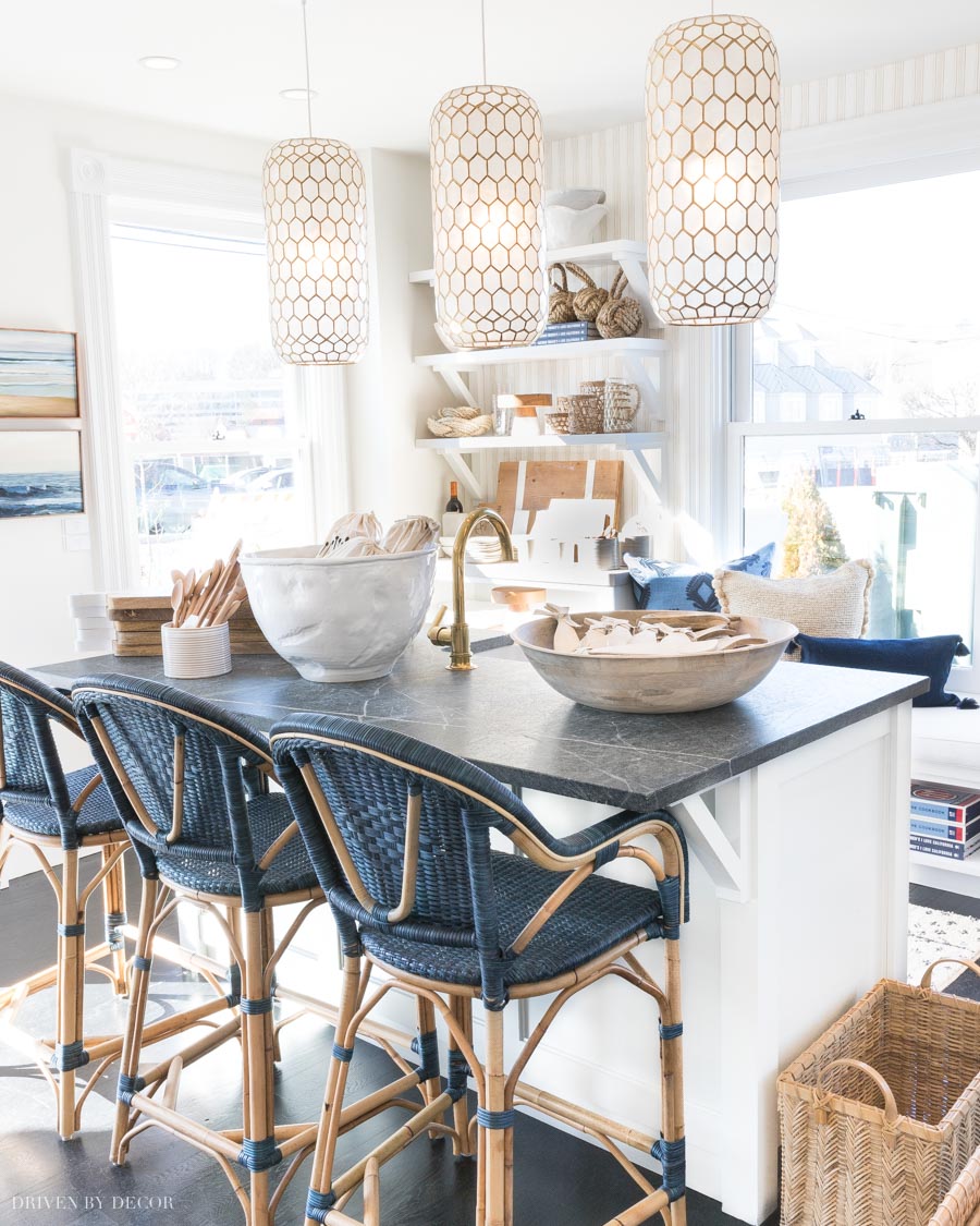 LOVE these blue woven counter stools at this kitchen island (and those pendants are gorgeous!)