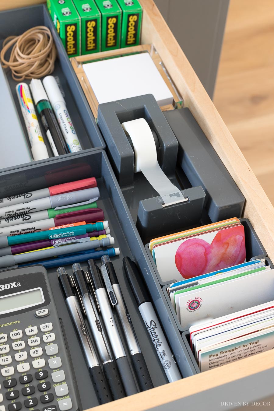 A kitchen command center in a hidden drawer holding tape, stapler, and all sorts of other essentials!