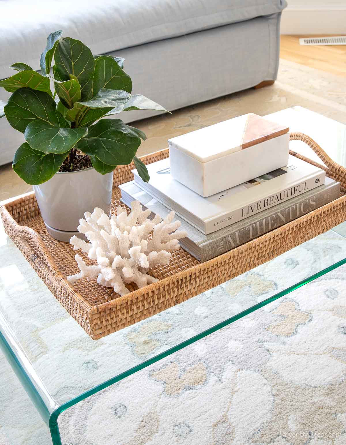 Woven tray holding coffee table decor