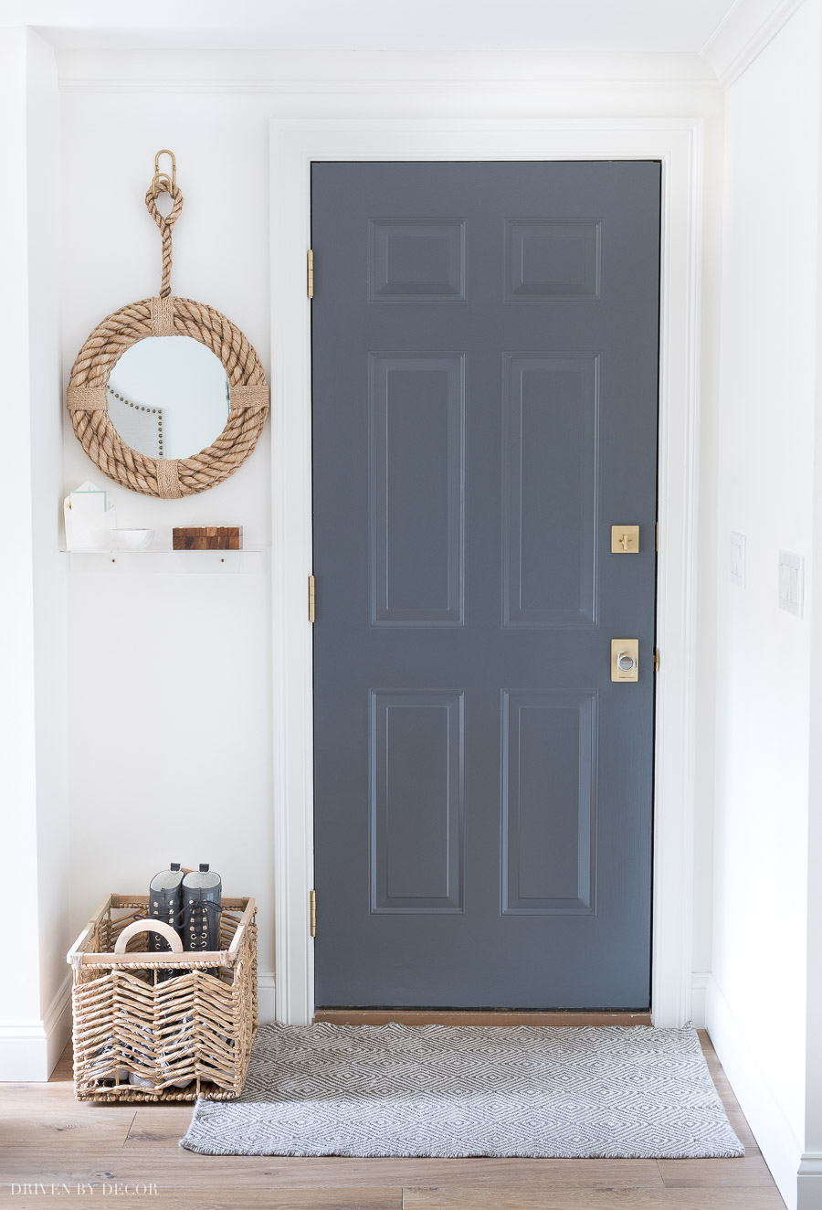 Love the small details of this garage entryway including the painted door, rug, mirror, and shelf!