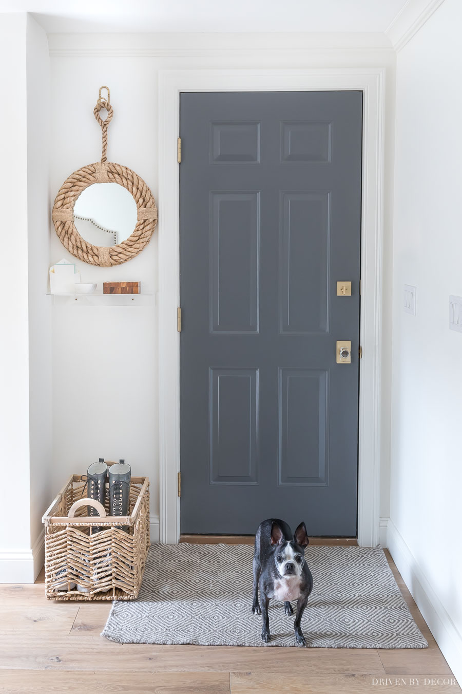 Such a cute small space entryway with rope mirror and shelf, rug, and basket for shoes!