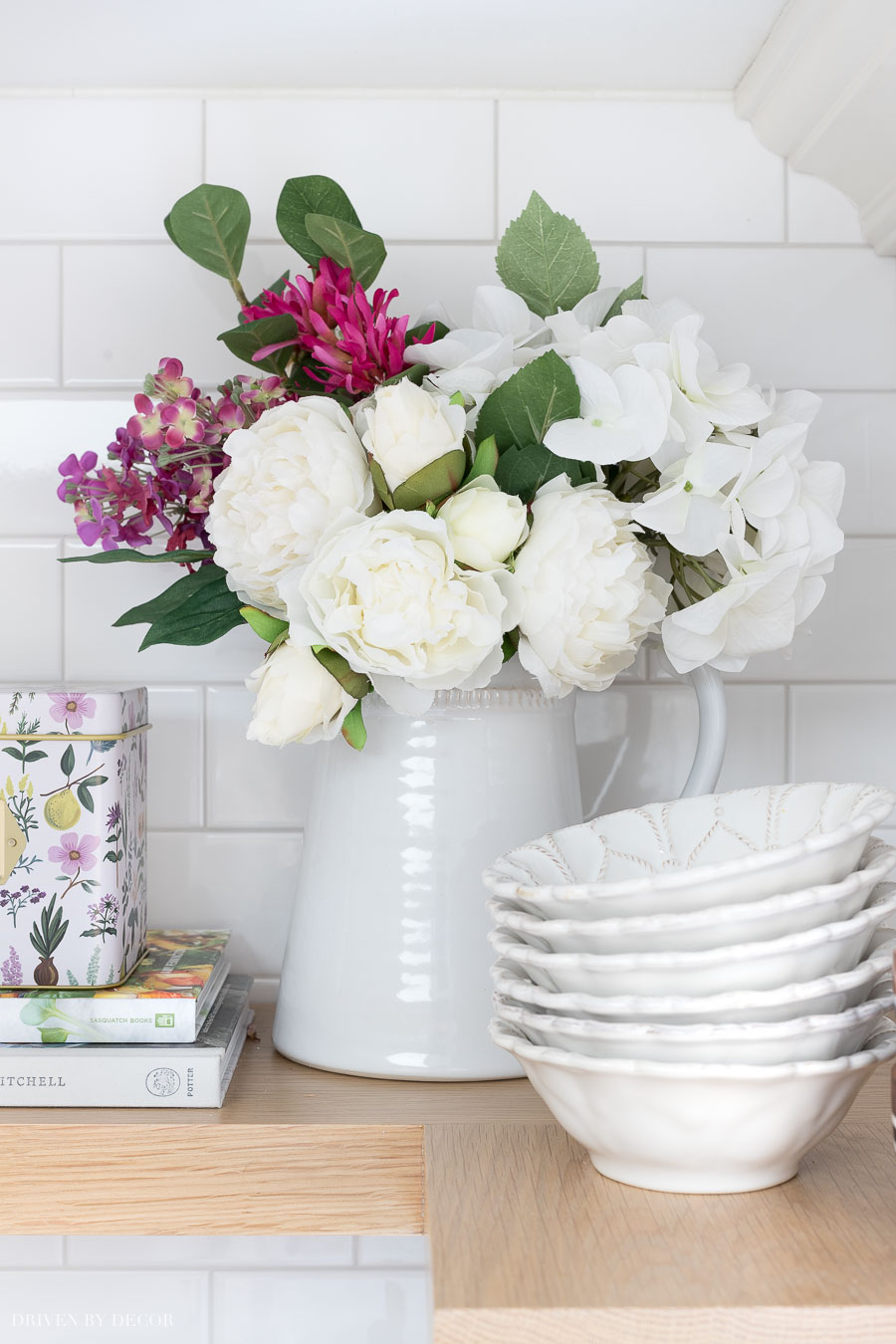 These realistic faux flowers in a pitcher are perfect for dressing up the look of your shelves!