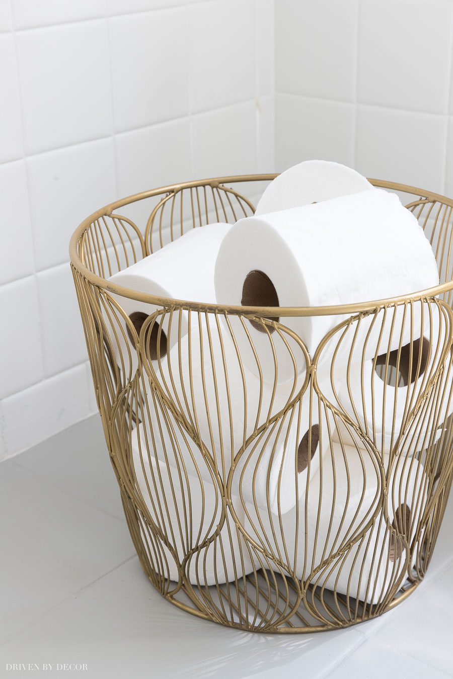 This small gold wire basket is perfect for holding extra rolls of toilet paper in the bathroom!