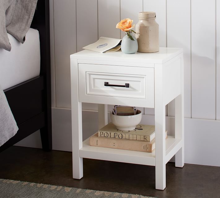 This small white nightstand is perfect for small spaces! Love the classic design with a drawer and shelf. 