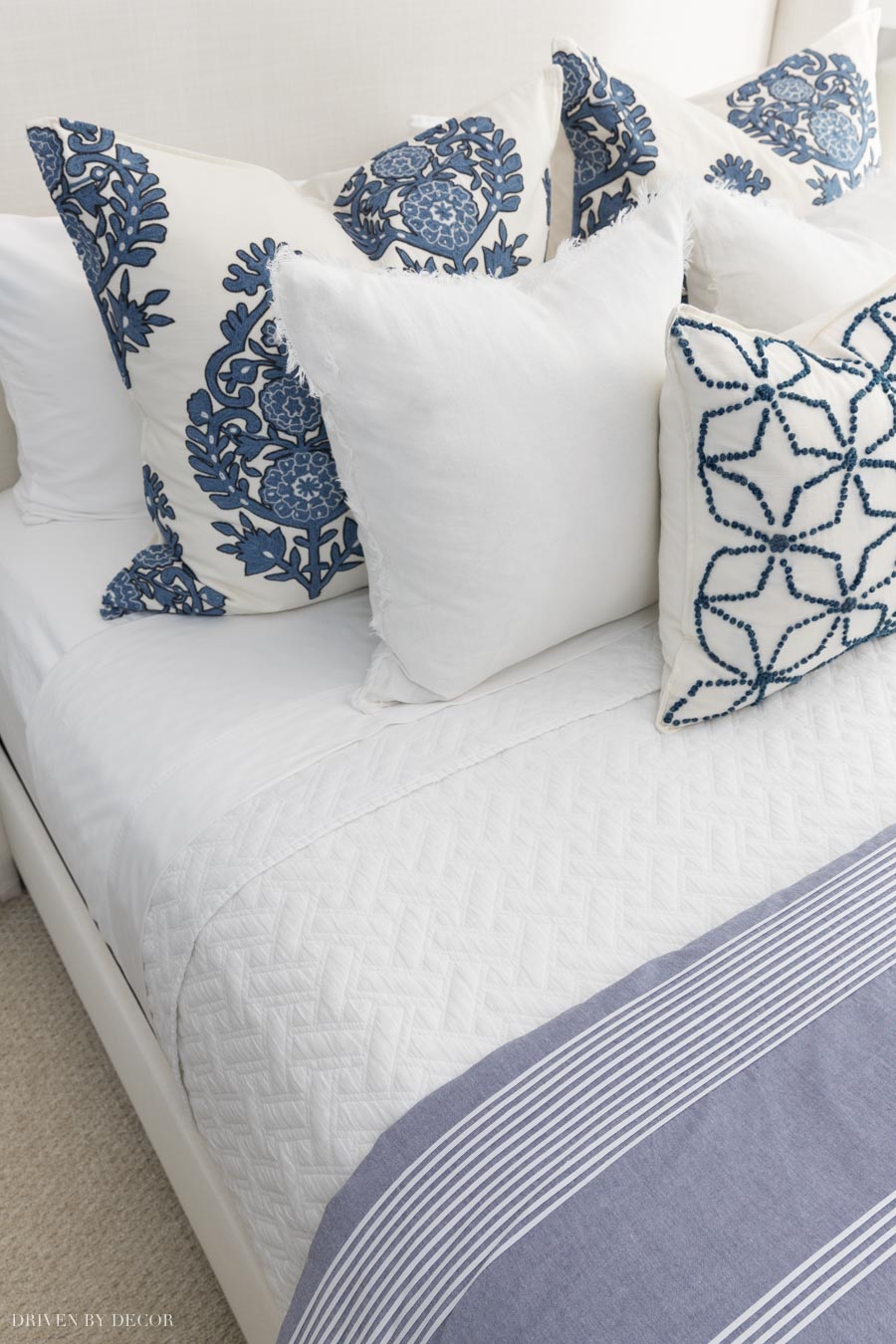 Sheets folded back over the coverlet on the bed