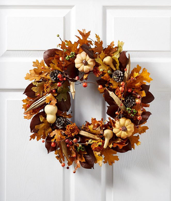 The perfect fall wreath for your front door with pumpkins, berries, and leaves