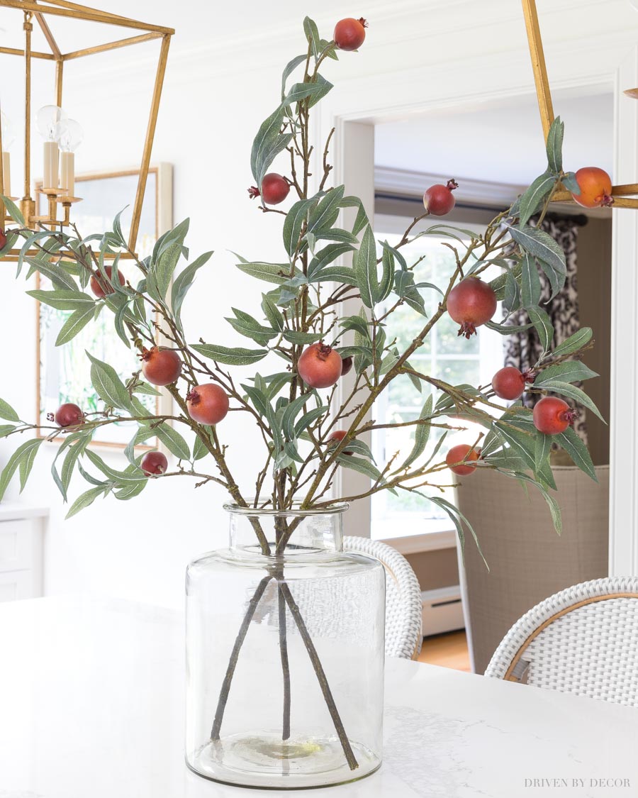 Love this simple but beautiful fall arrangement with faux pomegranate branches in a glass vase - sources linked in post!