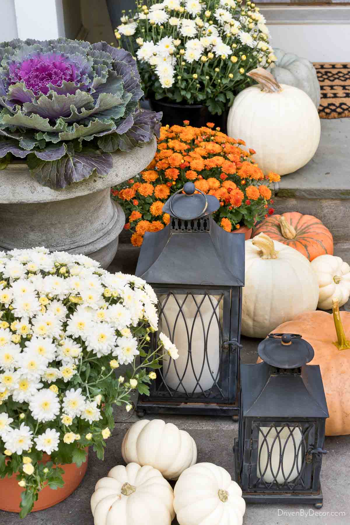 Pumpkins, mums, and lanterns on our fall front porch steps