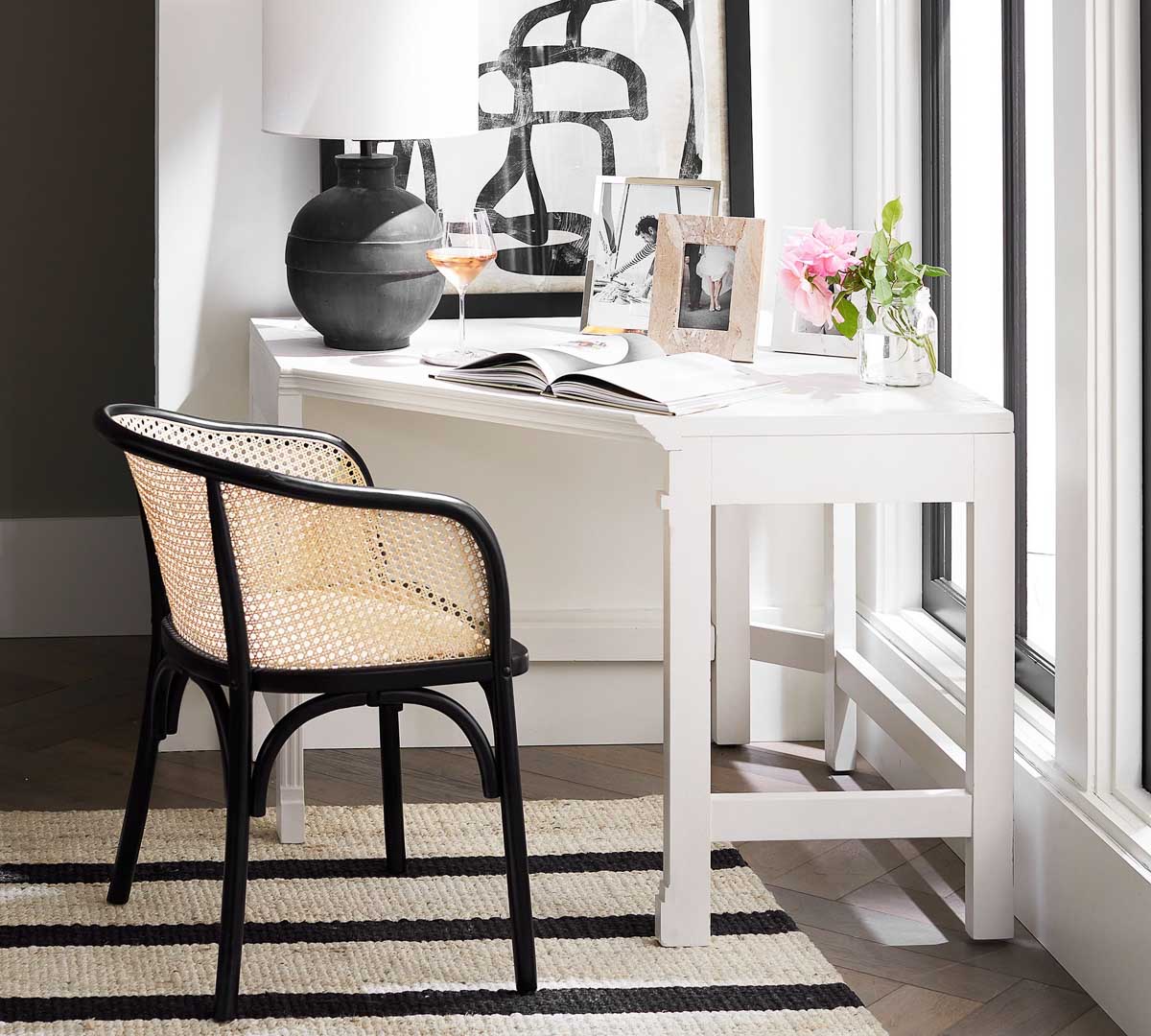 White corner desk with black cane chair - a living room corner idea