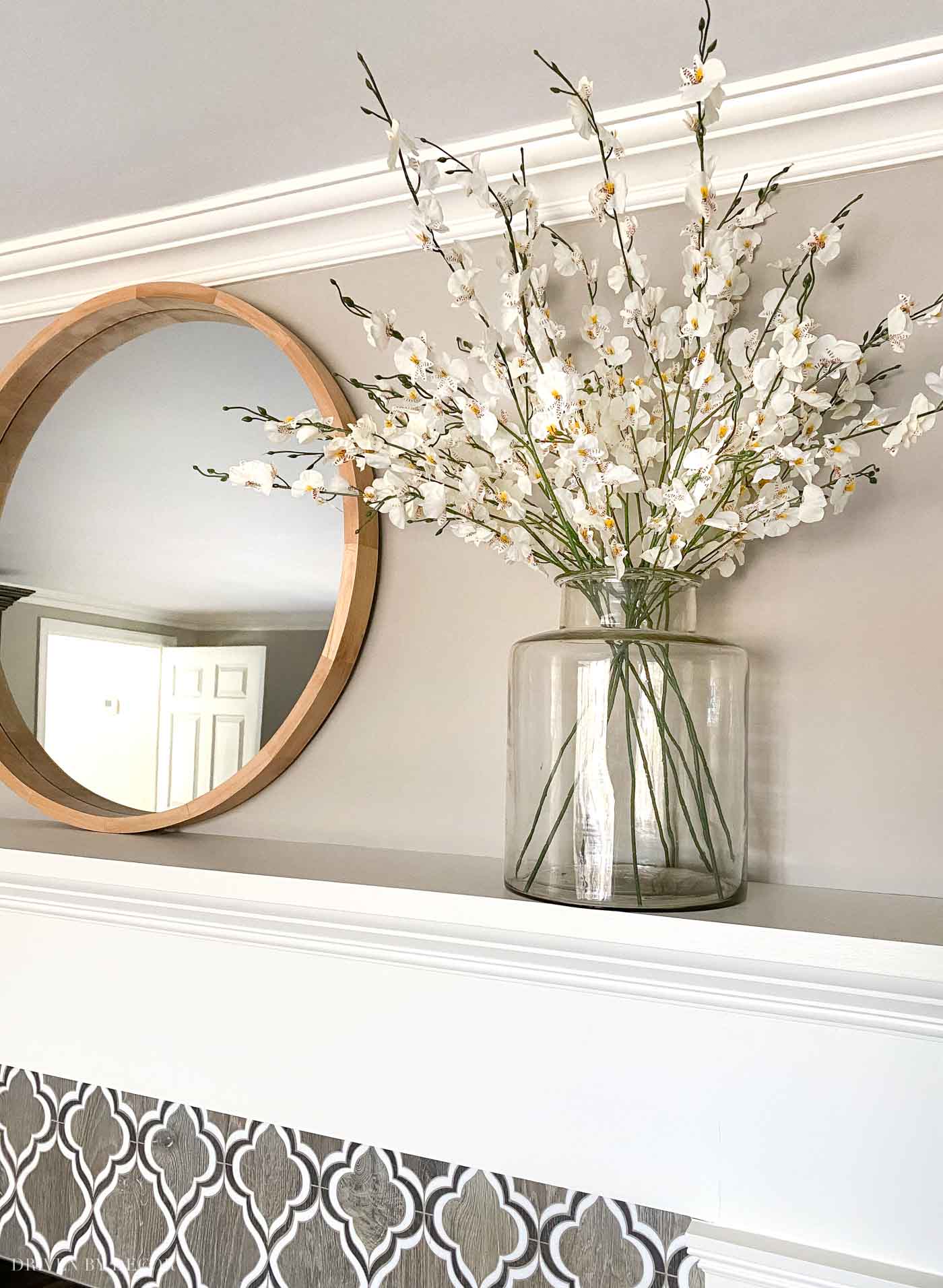 Love having a round mirror above the fireplace to reflect light around our room!