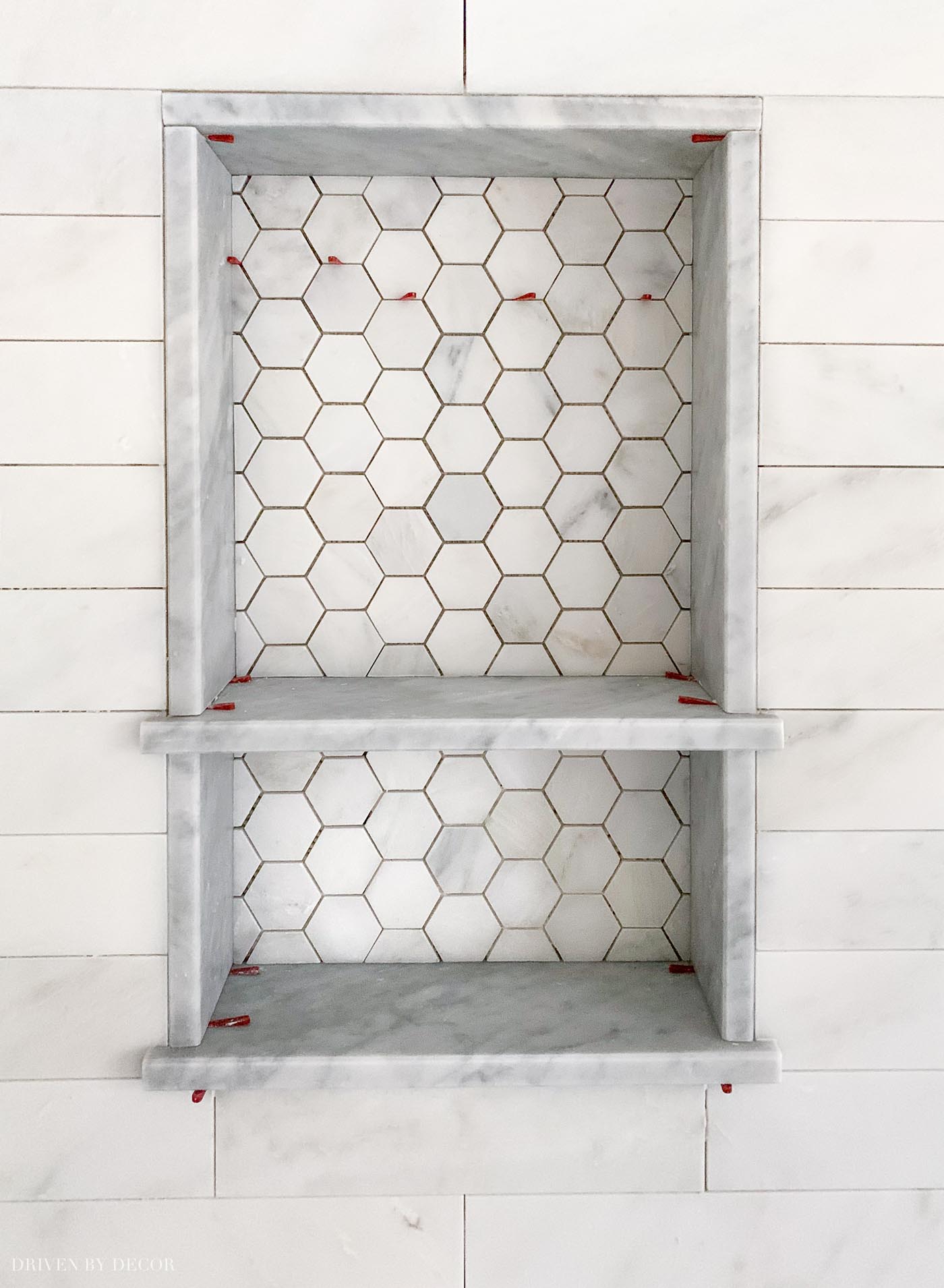 Gorgeous marble shower niche! Love the hexagon tile on the back of it!