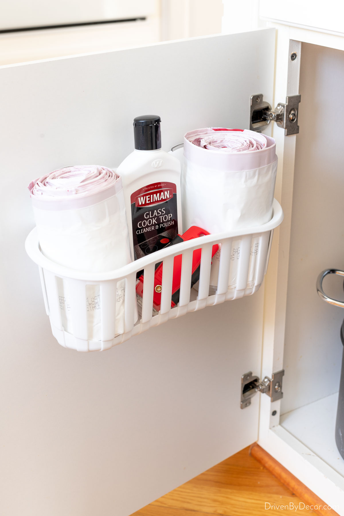 Cabinet caddy holding trash bags on cabinet door