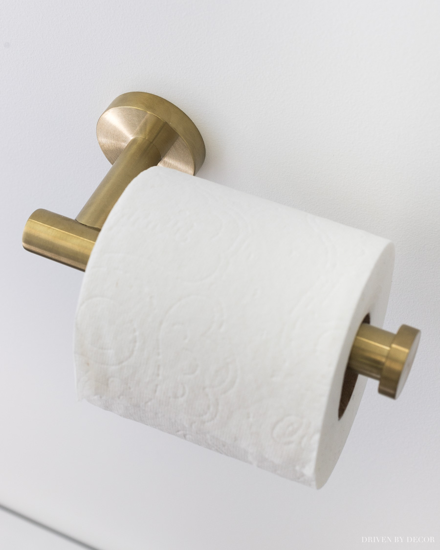 Beautiful but inexpensive brass toilet paper holder! Love all of her other bathroom decor ideas too!