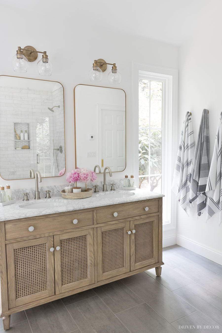 Love the layout of this double vanity between narrow windows and robe hooks on the wall for towels!