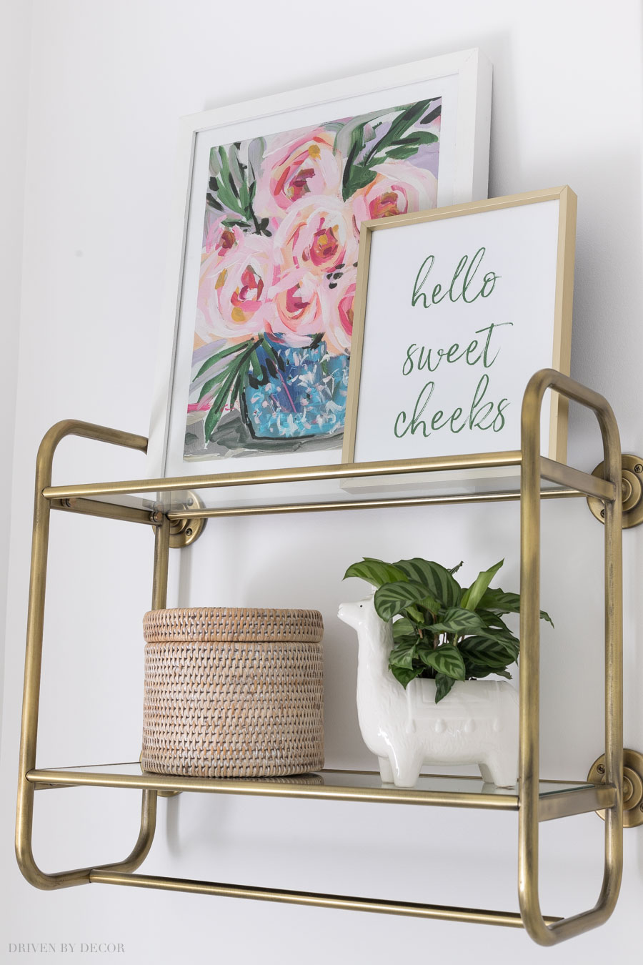 Love this brass wall shelf over the toilet