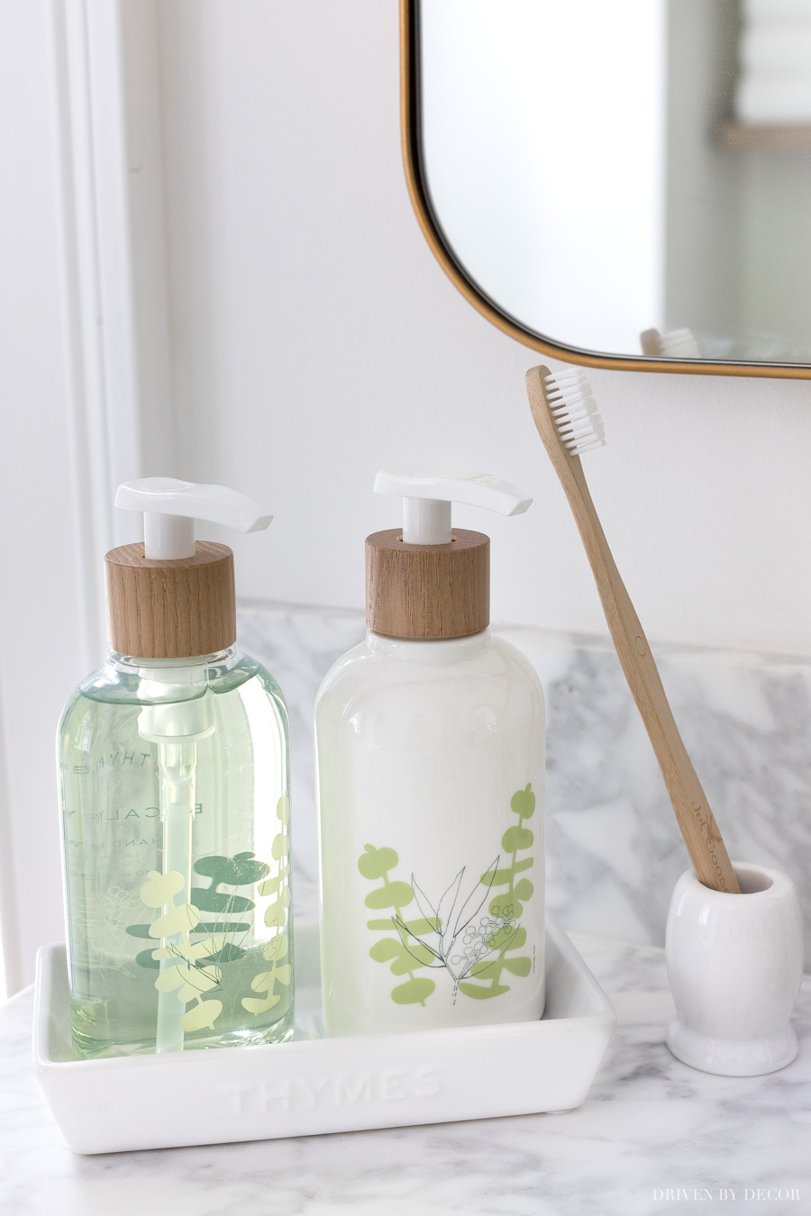 Soap and lotion pumps sit perfectly in this white tray by the bathroom sink. Love this simple toothbrush holder too!