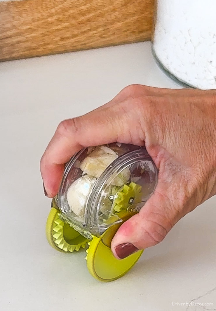 Cutting garlic with kitchen gadget that's a garlic chopper on wheels