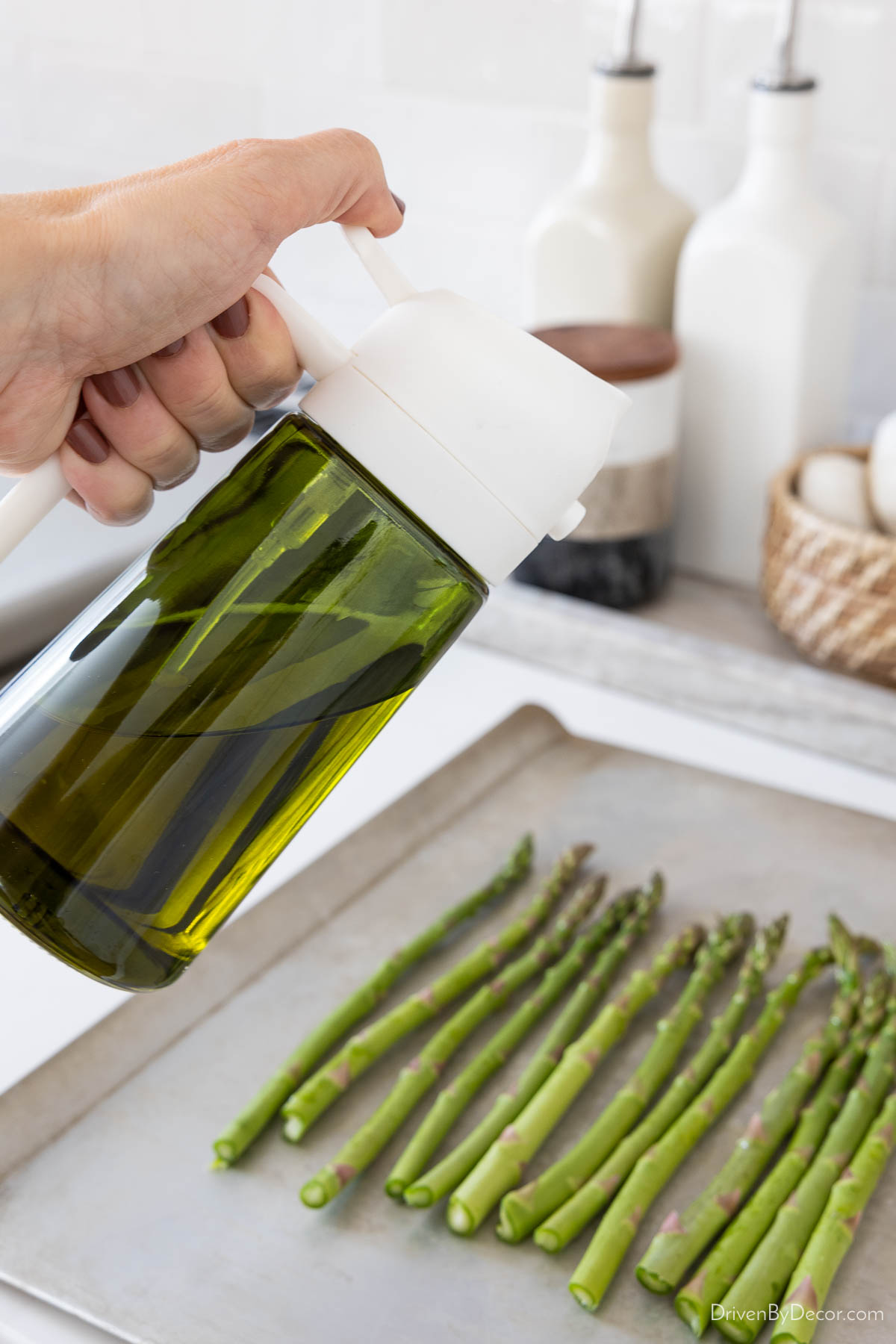 Spraying asparagus with olive oil sprayer