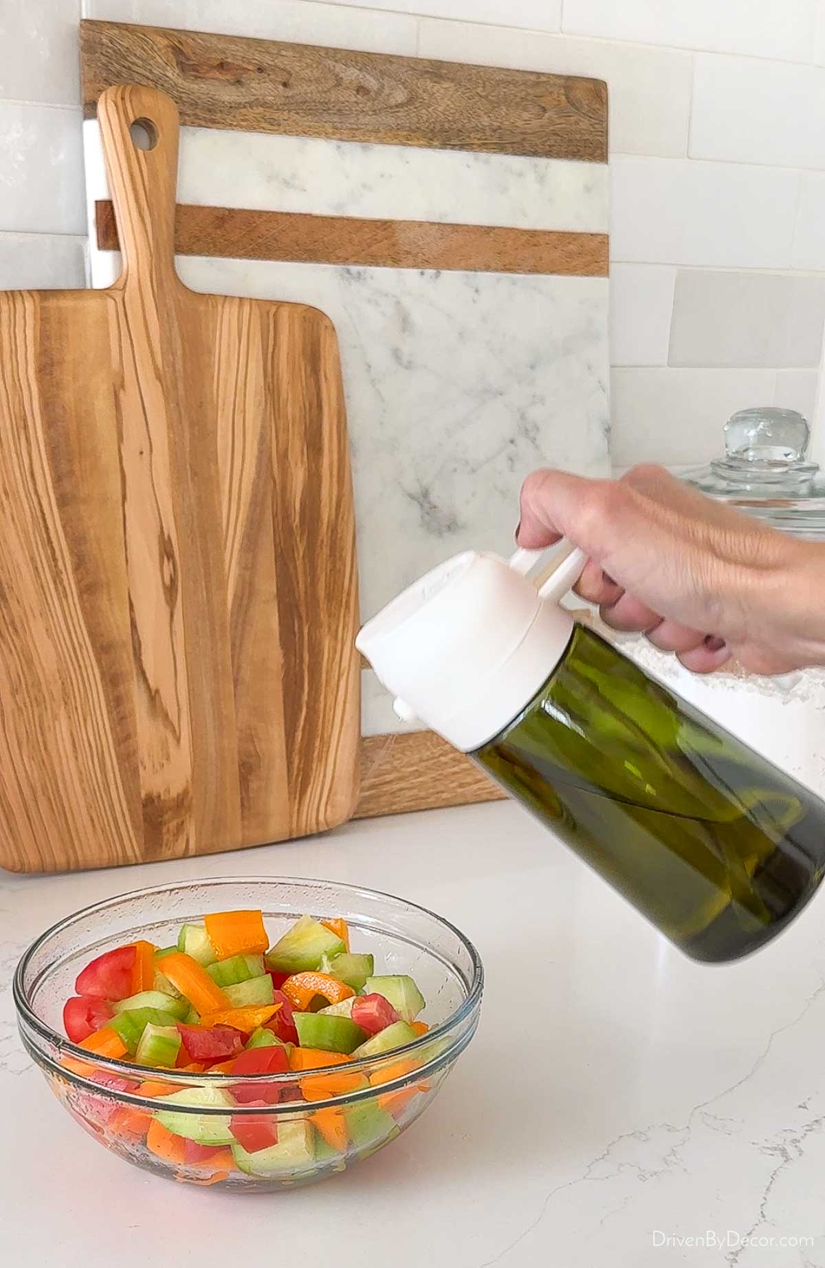 Spraying olive oil on veggie salad