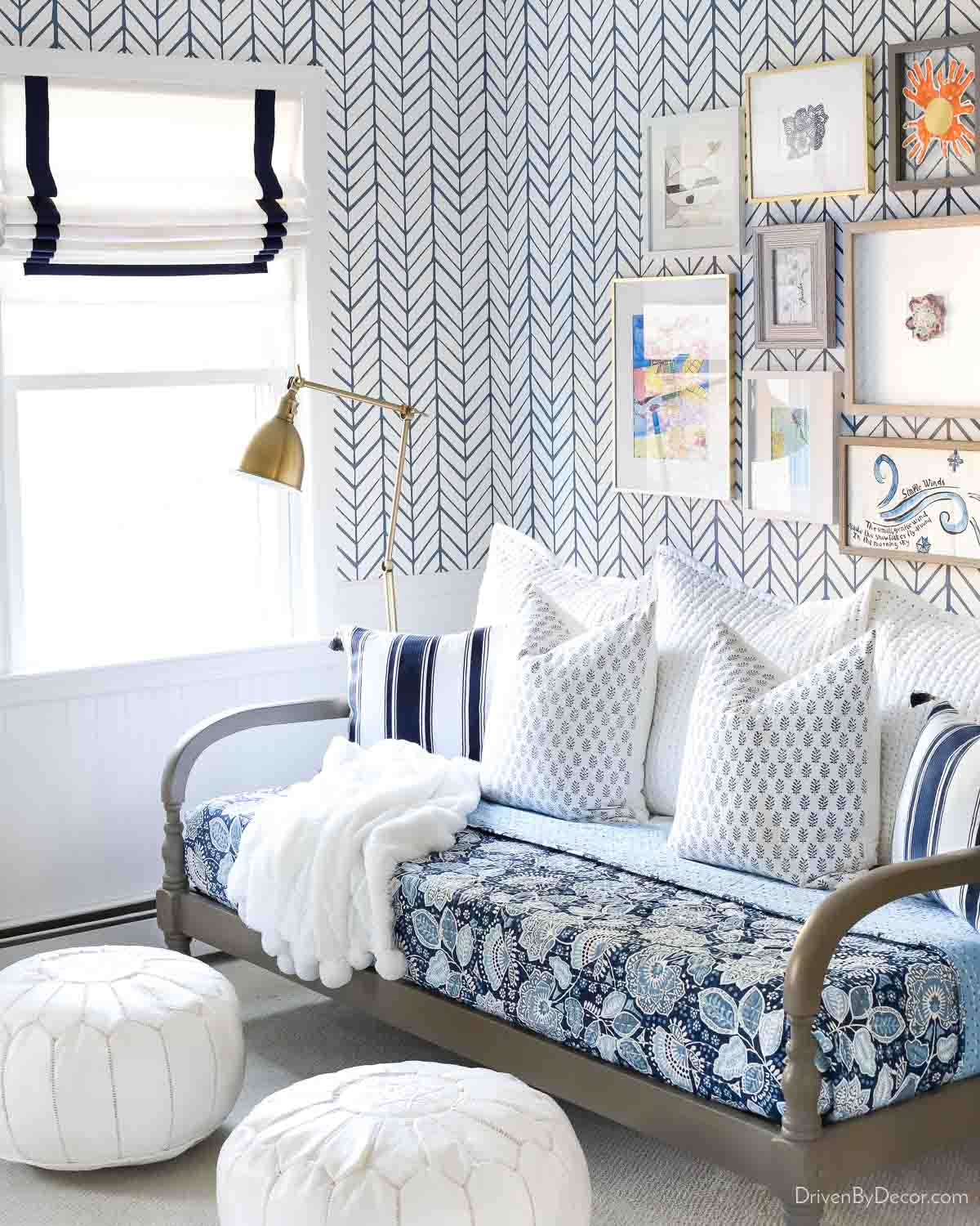 White Roman shades with navy trim in room with daybed