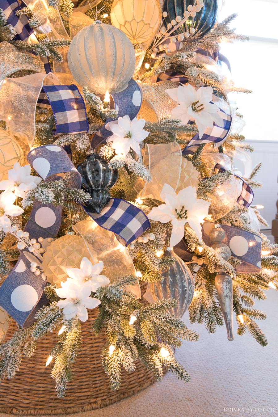 Love the mix of ribbon, ornaments, poinsettias, and berries on this Christmas tree!