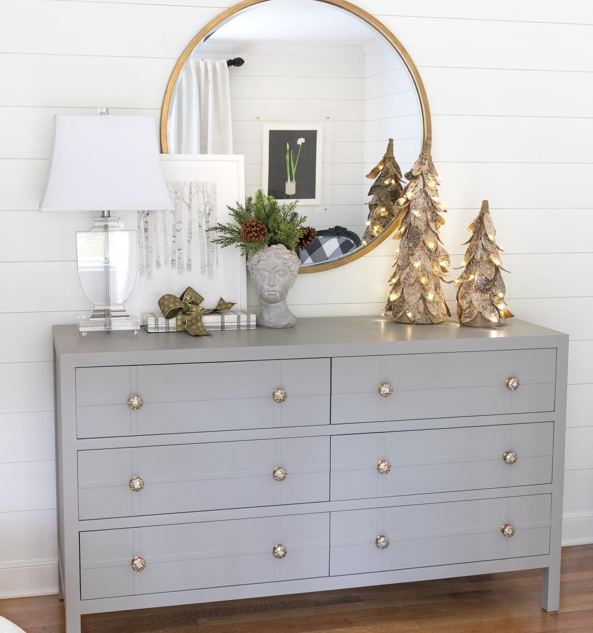 Christmas decor in our bedroom including faux greenery in my bust planter and birch Christmas trees