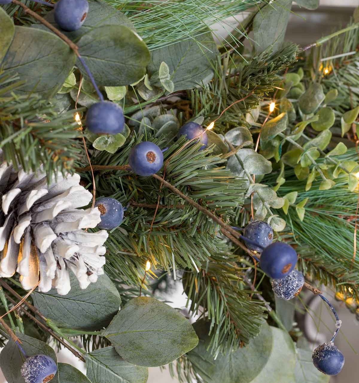 Our Christmas garland with faux pine, eucalyptus, frosted berries, and pinecones