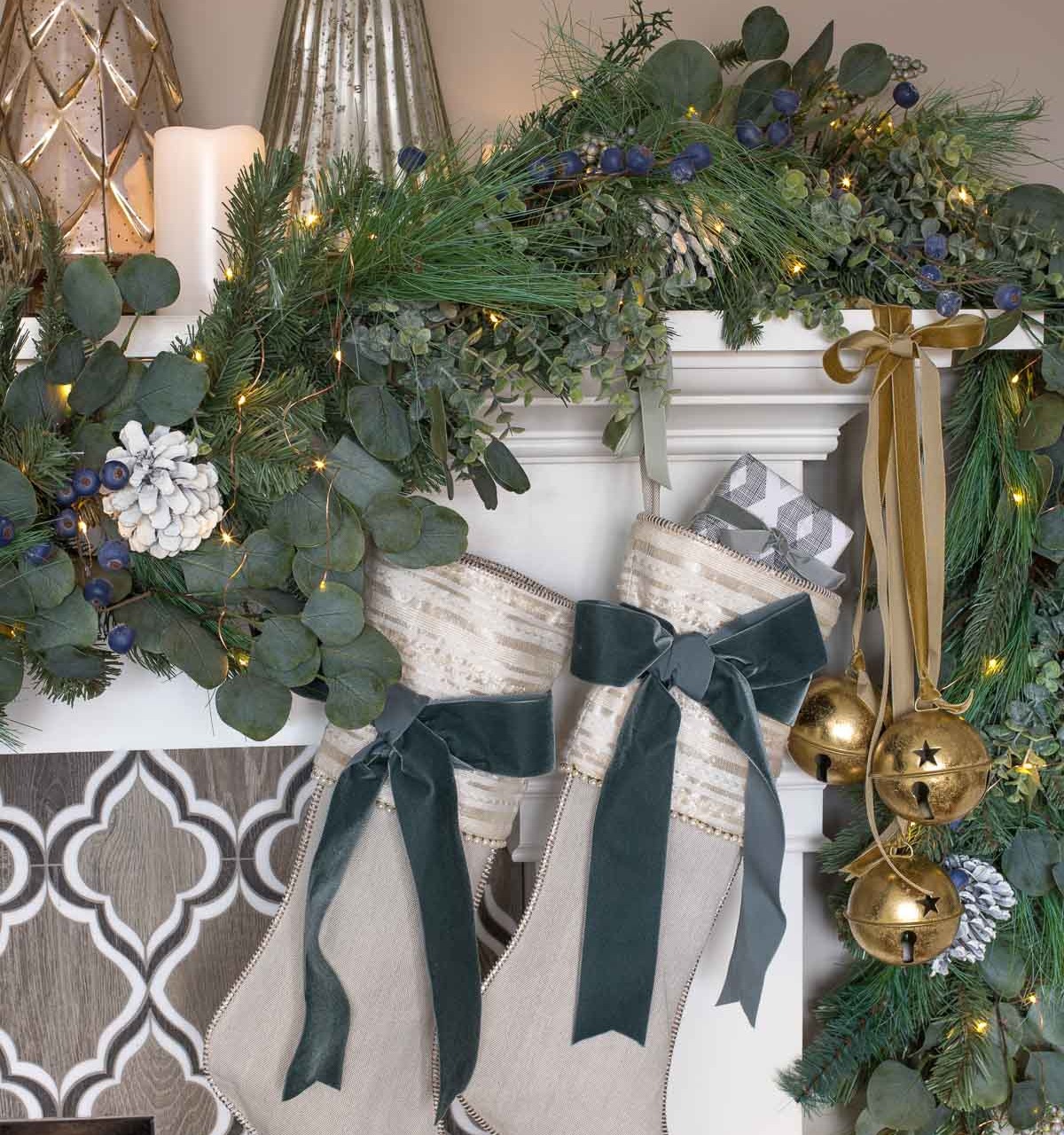 Large gold jingle bells tied with velvet ribbon on our fireplace mantel for Christmas