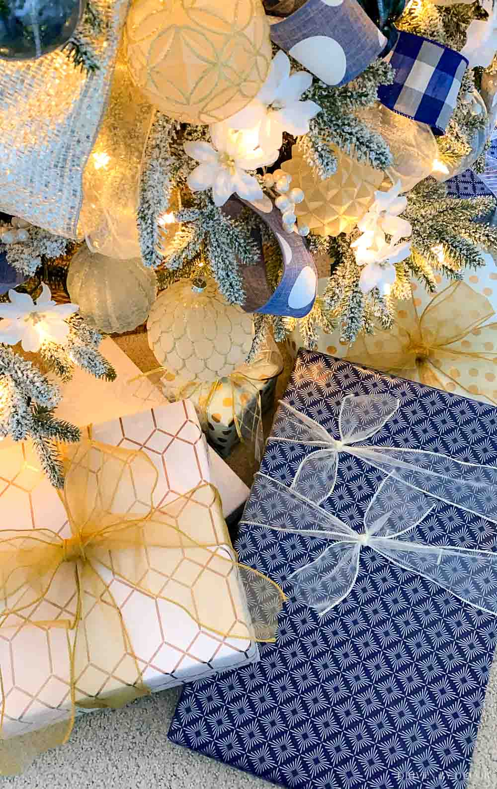 Packages wrapped in blue and white under the Christmas tree