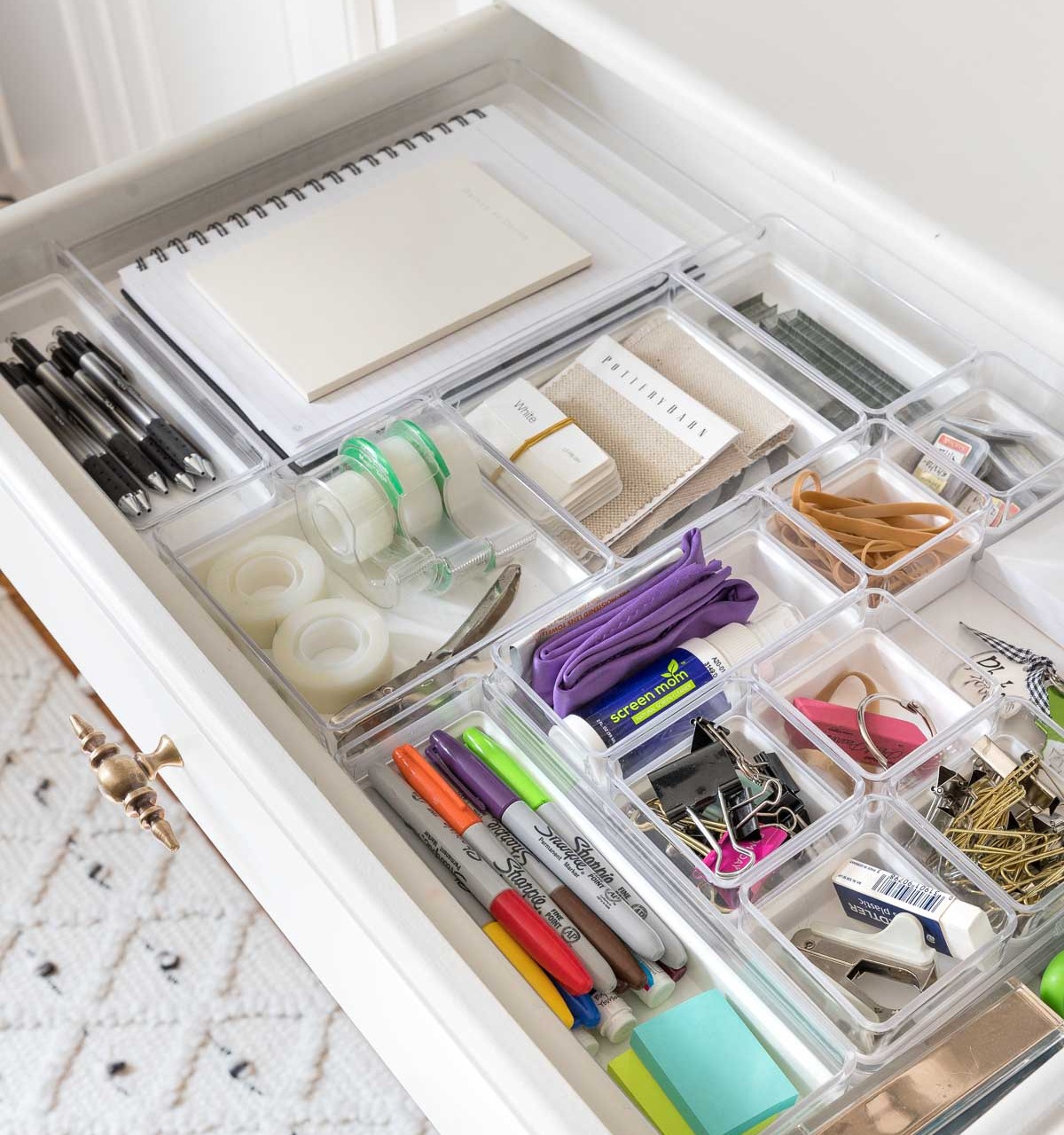 Drawer with plastic organizers organizing office supplies
